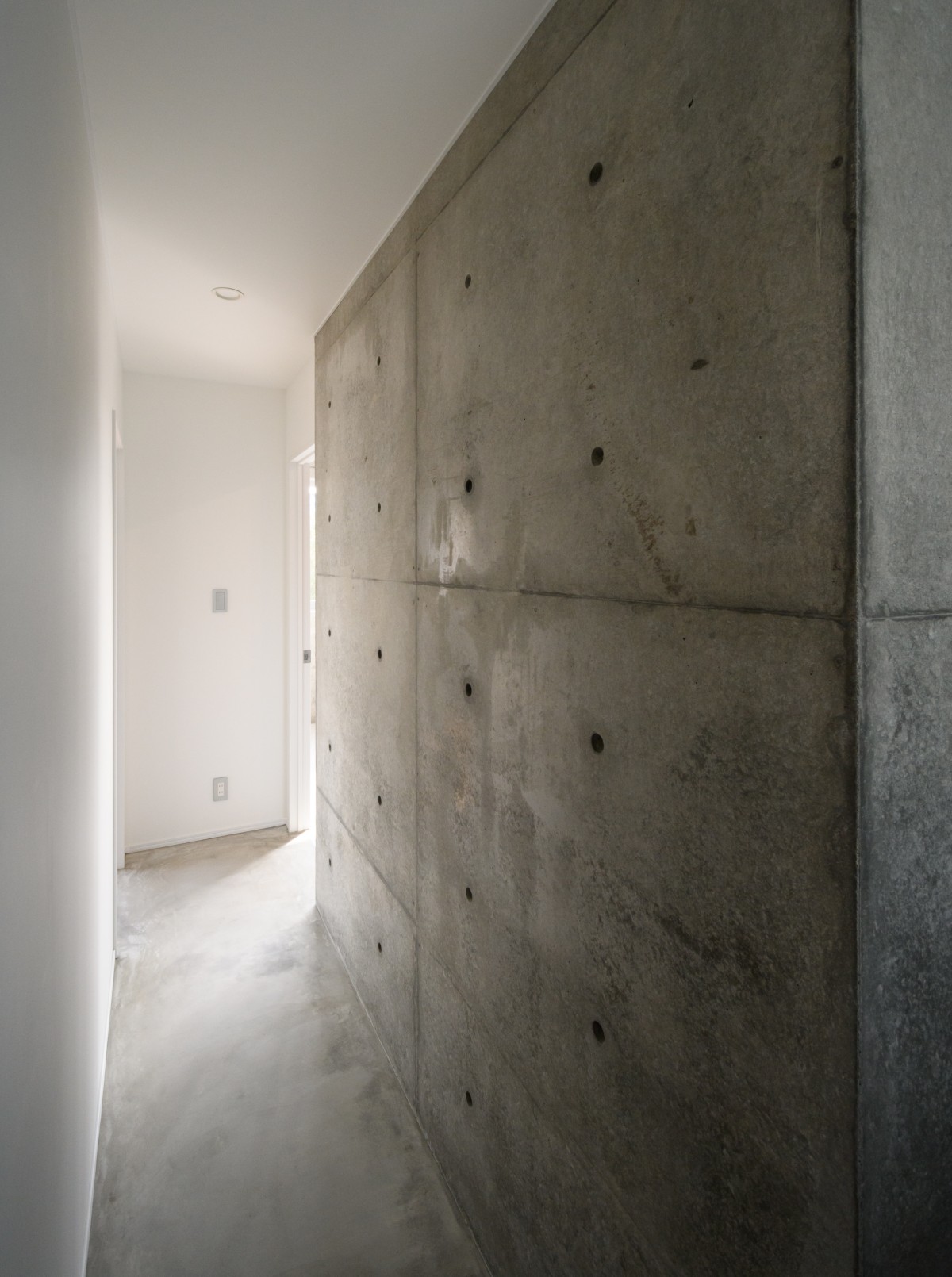 コンクリート打放壁のある廊下
